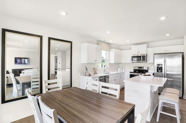 kitchen featuring white cabinetry, a center island, sink, dark wood-type flooring, and appliances with stainless steel finishes