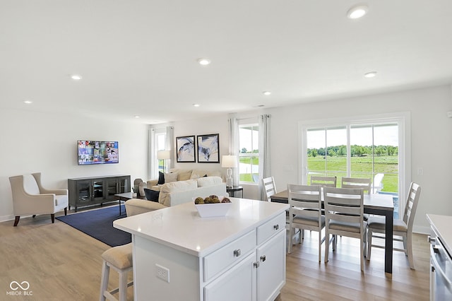 kitchen featuring white cabinets, a kitchen island, and light hardwood / wood-style flooring