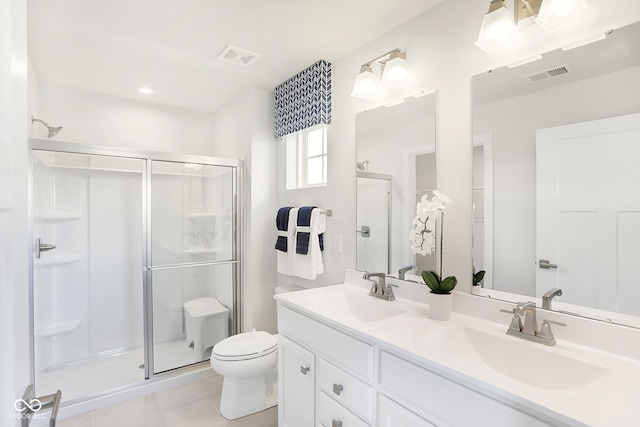 bathroom with tile patterned floors, a shower with door, vanity, and toilet