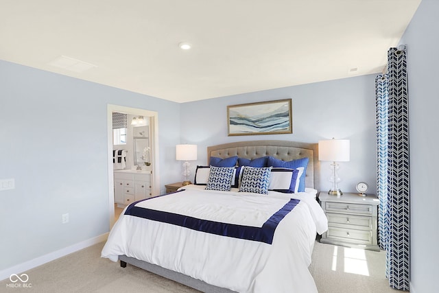 bedroom featuring connected bathroom and light colored carpet