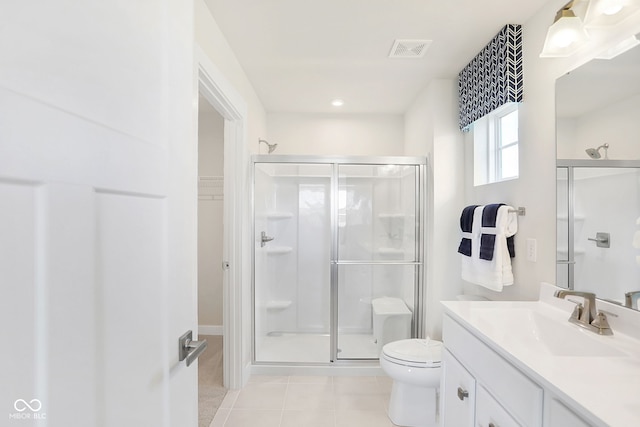 bathroom with tile patterned floors, vanity, toilet, and a shower with door