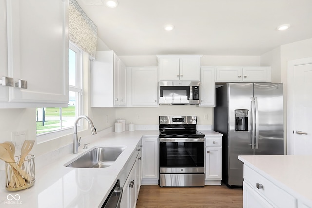 kitchen with dark hardwood / wood-style flooring, white cabinetry, sink, and stainless steel appliances