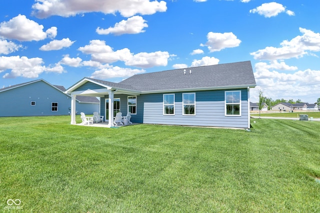 rear view of property with a lawn and a patio