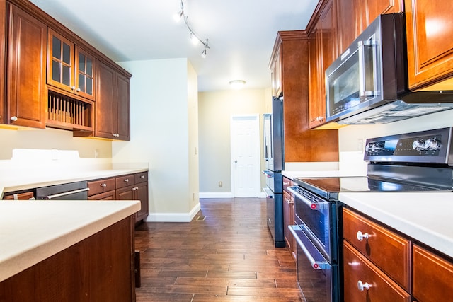 kitchen featuring rail lighting, dark hardwood / wood-style flooring, and appliances with stainless steel finishes