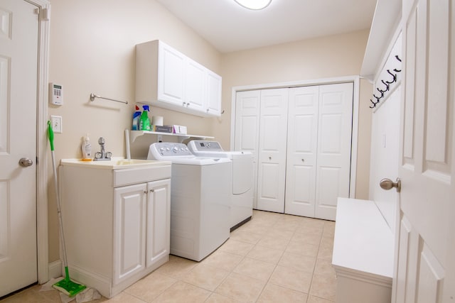 clothes washing area featuring washer and dryer, cabinets, sink, and light tile floors