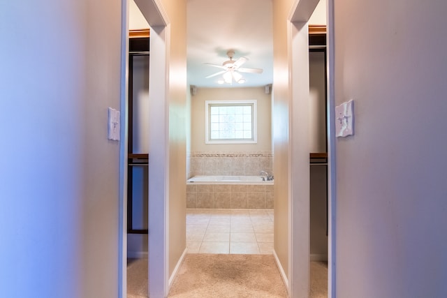 bathroom with tile floors, a relaxing tiled bath, and ceiling fan