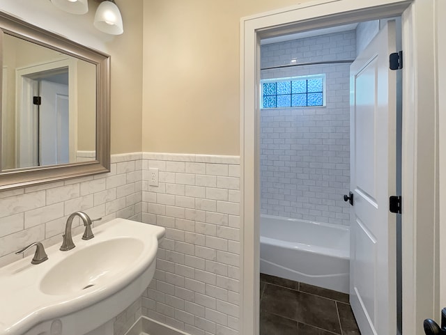 bathroom with tile walls, tile floors, sink, and tiled shower / bath