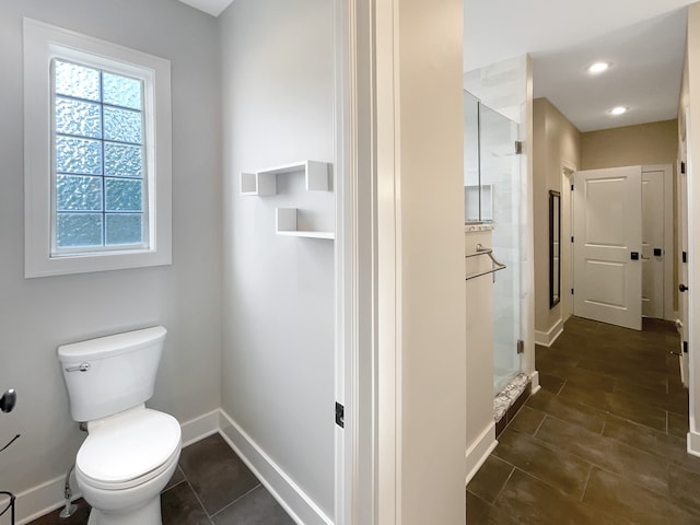 bathroom with tile floors, a shower with door, and toilet