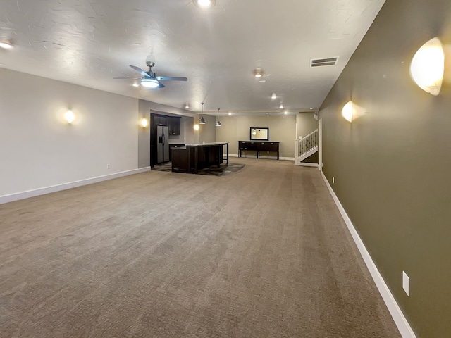 unfurnished living room with ceiling fan and light carpet