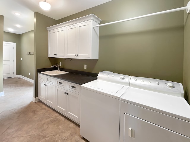 washroom featuring washer and dryer, cabinets, sink, and light tile flooring