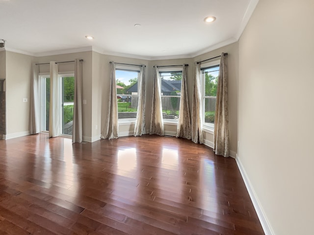 spare room featuring dark hardwood / wood-style flooring and crown molding