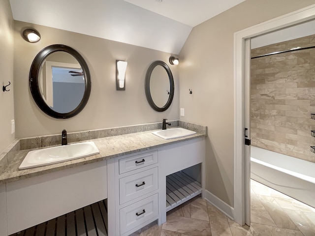 bathroom featuring tile flooring, double sink vanity, tiled shower / bath combo, and lofted ceiling