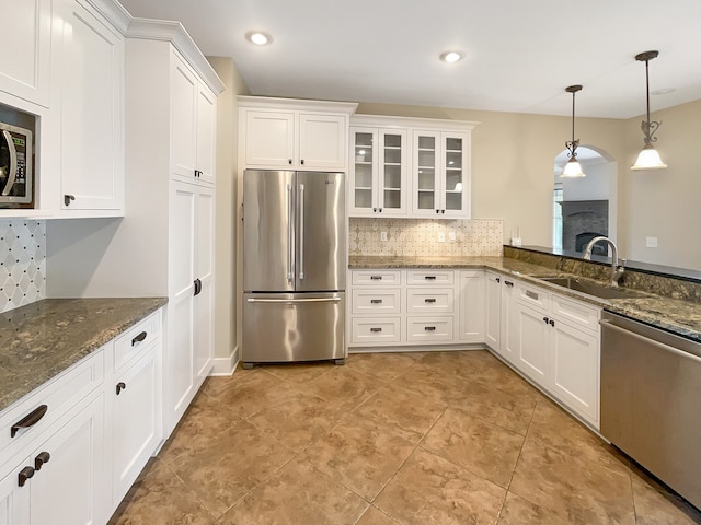 kitchen featuring tasteful backsplash, white cabinetry, appliances with stainless steel finishes, sink, and light tile floors