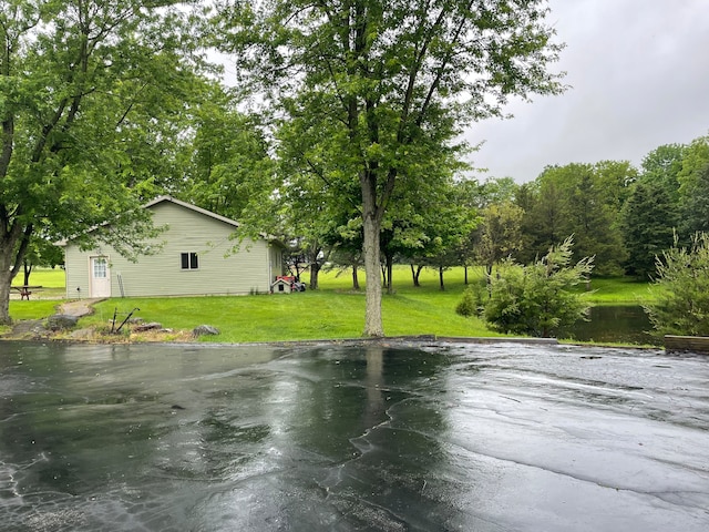 view of basketball court featuring a yard and a water view