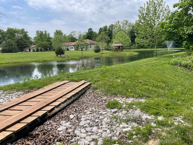 view of property's community with a lawn and a water view