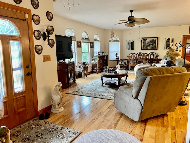 living room featuring ceiling fan, a healthy amount of sunlight, and light wood-type flooring