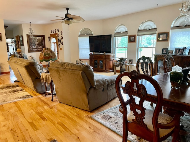 living room featuring wood-type flooring and ceiling fan with notable chandelier