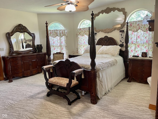 carpeted bedroom featuring multiple windows and ceiling fan