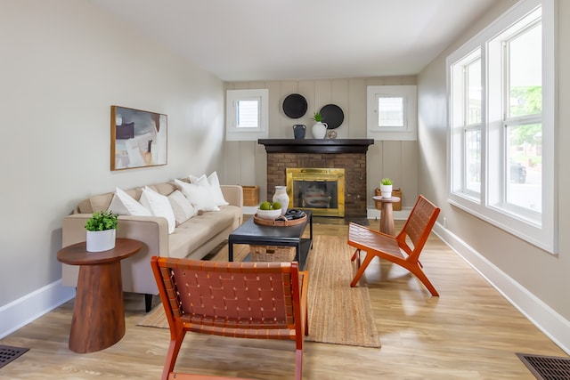 living room featuring wood-type flooring and a brick fireplace