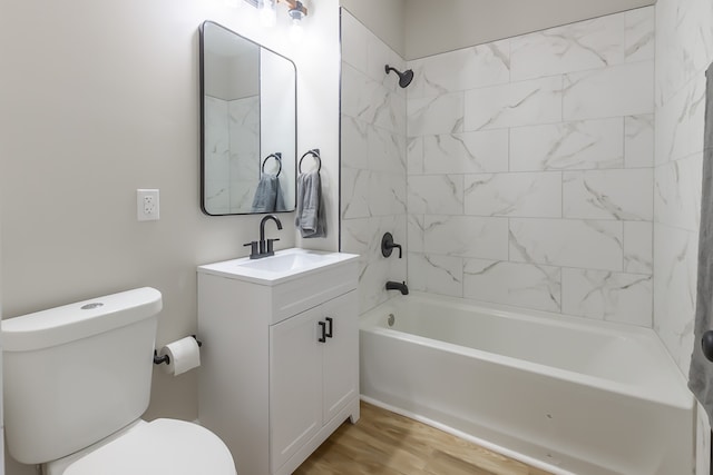 full bathroom featuring wood-type flooring, vanity, toilet, and tiled shower / bath combo