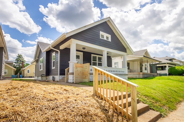 bungalow-style home featuring a front lawn and covered porch