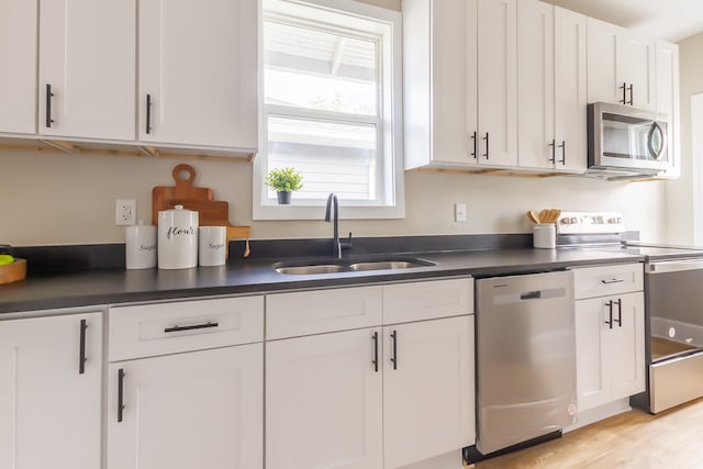 kitchen featuring white cabinetry, sink, light hardwood / wood-style flooring, and stainless steel appliances