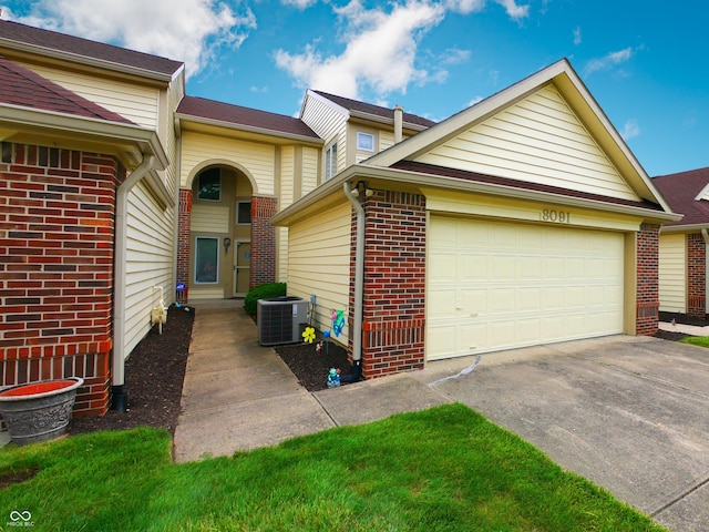 view of front of property with a garage and central AC