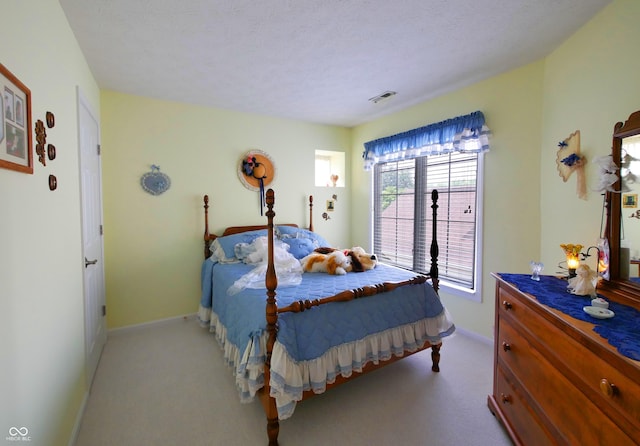 bedroom featuring a textured ceiling and light carpet