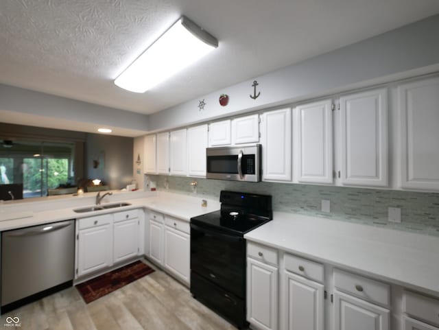 kitchen with stainless steel appliances, white cabinets, sink, and light wood-type flooring