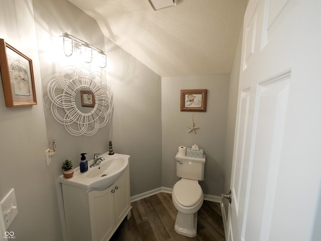 bathroom featuring lofted ceiling, toilet, hardwood / wood-style floors, a textured ceiling, and vanity