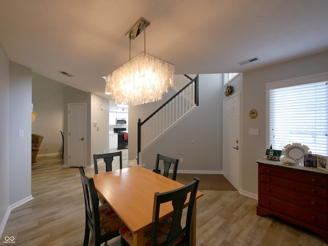 dining area with a chandelier and light hardwood / wood-style flooring