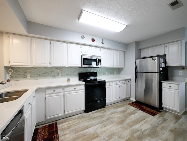 kitchen featuring light wood-type flooring, white cabinets, sink, and stainless steel appliances