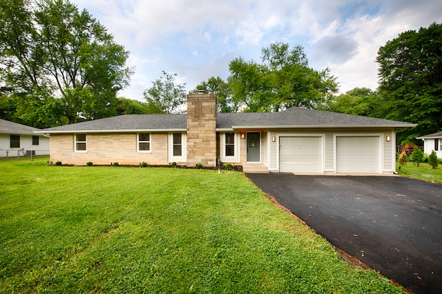 ranch-style home featuring a front lawn and a garage