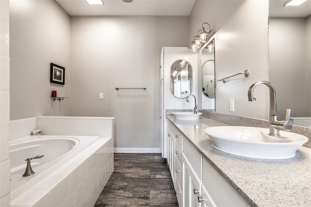 bathroom featuring tile flooring, oversized vanity, double sink, and tiled tub