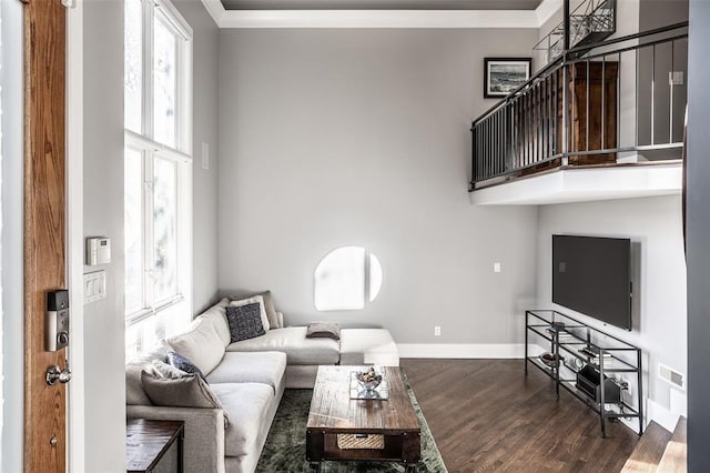 living room with a towering ceiling, dark hardwood / wood-style flooring, and crown molding