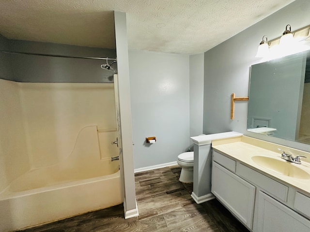 full bathroom with tub / shower combination, a textured ceiling, hardwood / wood-style flooring, toilet, and vanity