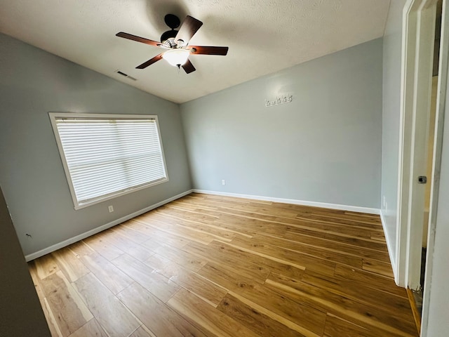 unfurnished room featuring a textured ceiling, lofted ceiling, ceiling fan, and light hardwood / wood-style flooring