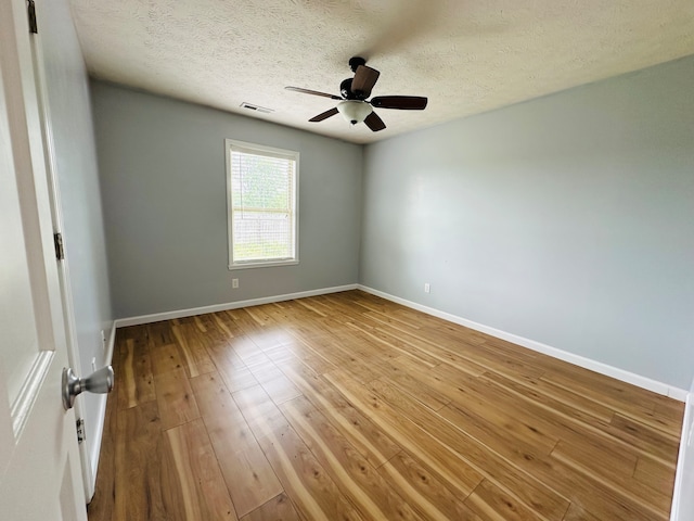 empty room with ceiling fan, a textured ceiling, and hardwood / wood-style flooring