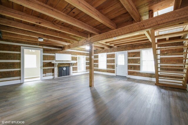 unfurnished living room with beam ceiling, dark wood-type flooring, and wood ceiling