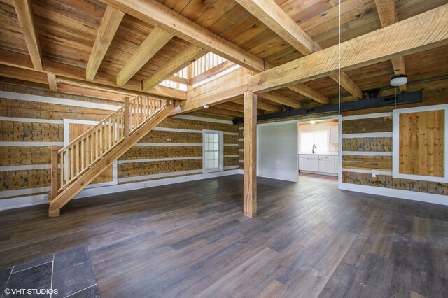 basement with dark wood-type flooring, sink, wood walls, and wooden ceiling