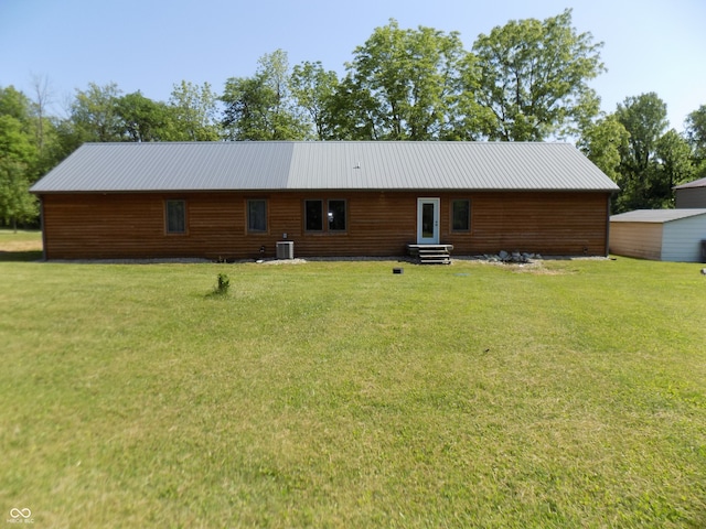 rear view of house with central AC and a yard