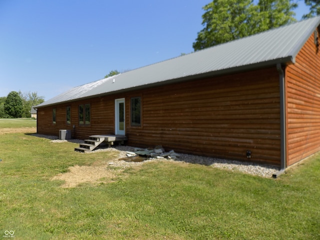 back of house featuring a lawn and cooling unit