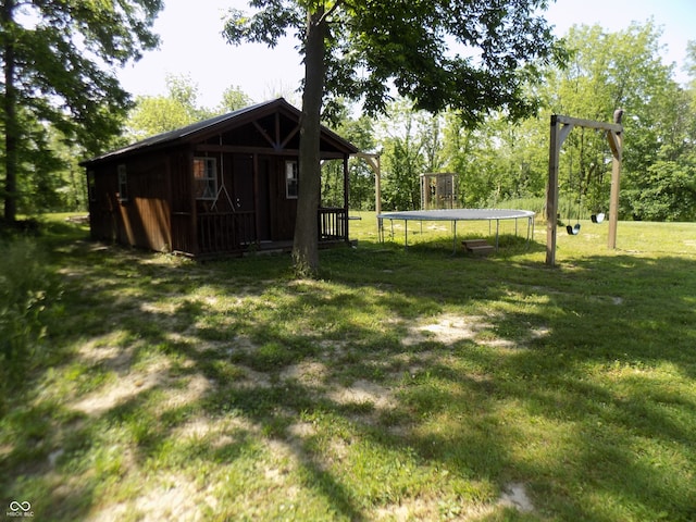 view of yard featuring an outdoor structure and a trampoline