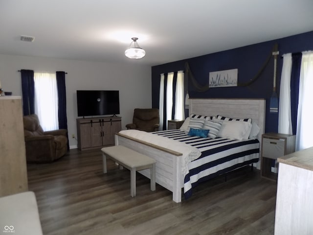 bedroom with a fireplace and dark hardwood / wood-style flooring