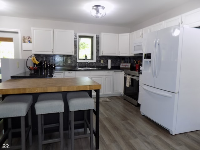 kitchen with plenty of natural light, sink, white appliances, and white cabinetry