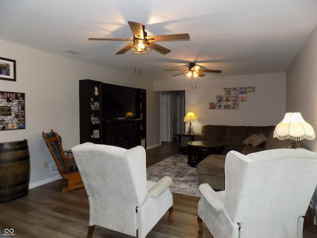 living room featuring dark wood-type flooring and ceiling fan