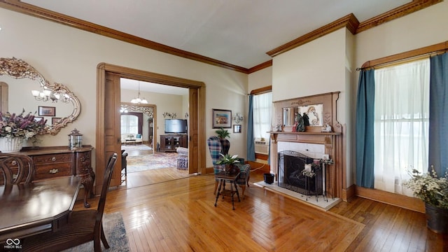 interior space featuring a wealth of natural light, a chandelier, hardwood / wood-style flooring, and crown molding