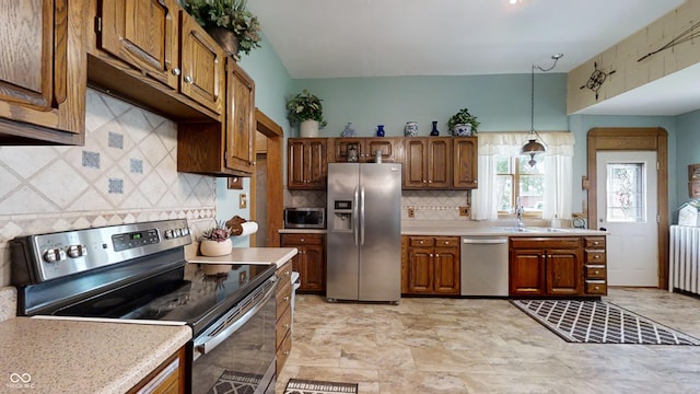 kitchen featuring decorative light fixtures, appliances with stainless steel finishes, tasteful backsplash, and light tile flooring