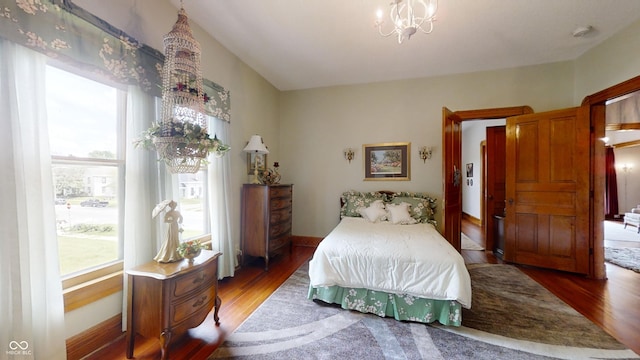 bedroom featuring dark wood-type flooring and an inviting chandelier