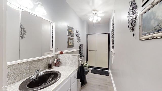 bathroom with ceiling fan, an enclosed shower, hardwood / wood-style flooring, and vanity